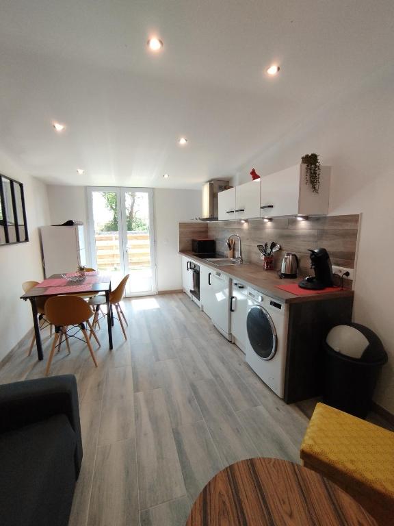 une cuisine avec une cuisinière et une table à l'intérieur dans l'établissement La chaumière, à Longues-sur-Mer