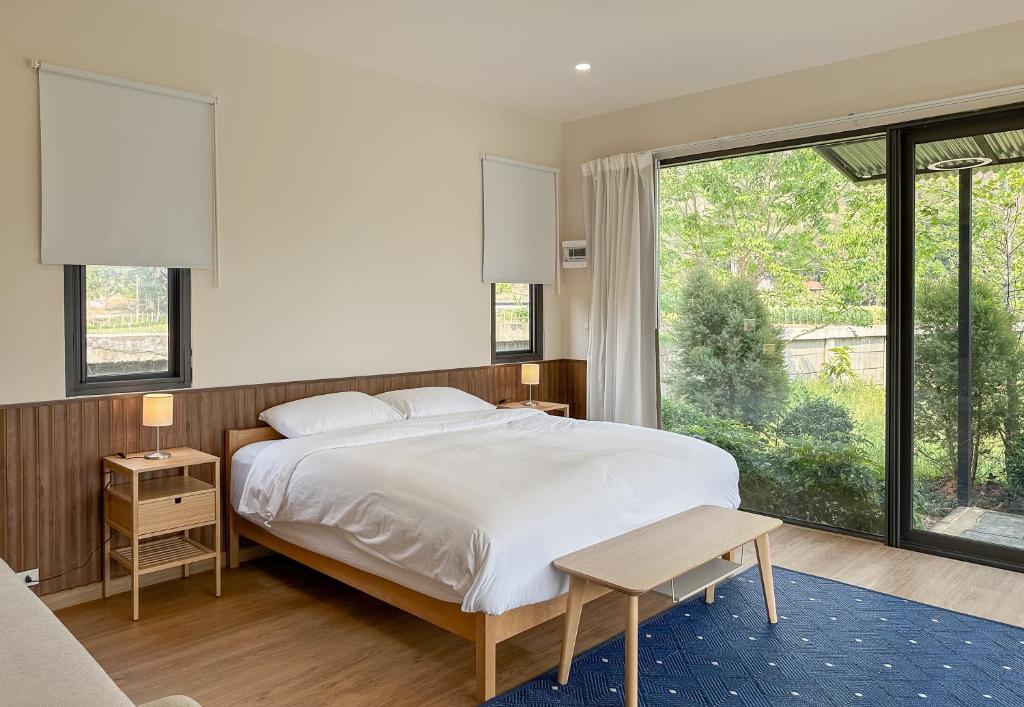1 dormitorio con cama grande y ventana grande en นาหมื่นสี สะเมิง Na Meun See Samoneg, en Ban Nam Rin