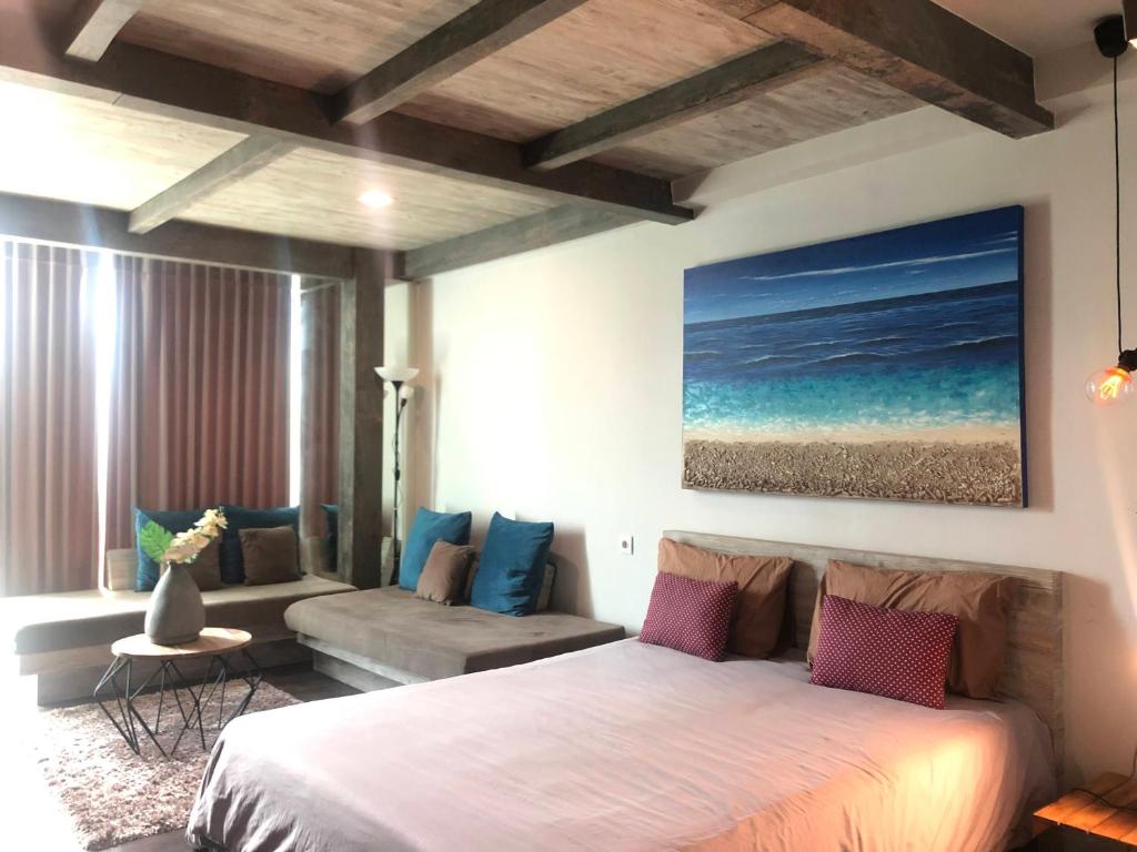 un dormitorio con una cama y un sofá en Lavenderbnb Room 5 at Mataram City, en Yogyakarta