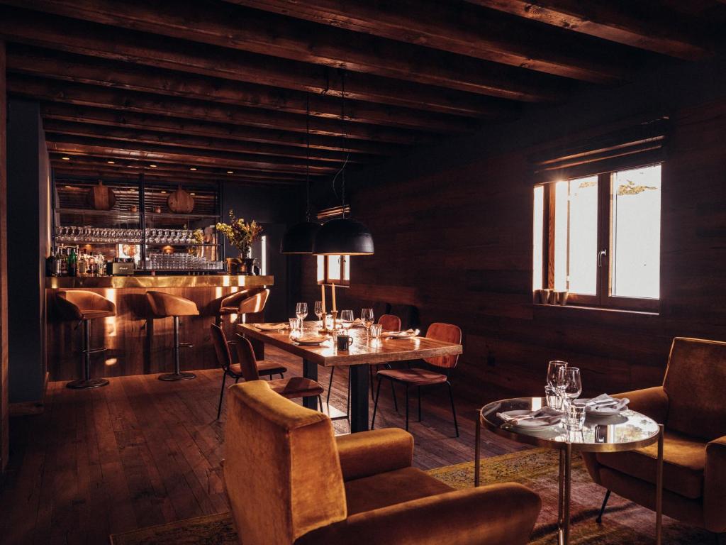 un restaurante con mesas y sillas y un bar en L´Ovella Negra Mountain Lodge en Canillo