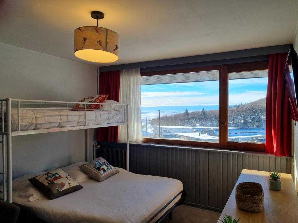 une chambre avec deux lits superposés et une fenêtre dans l'établissement Studio centre Super-Besse, à Besse-et-Saint-Anastaise