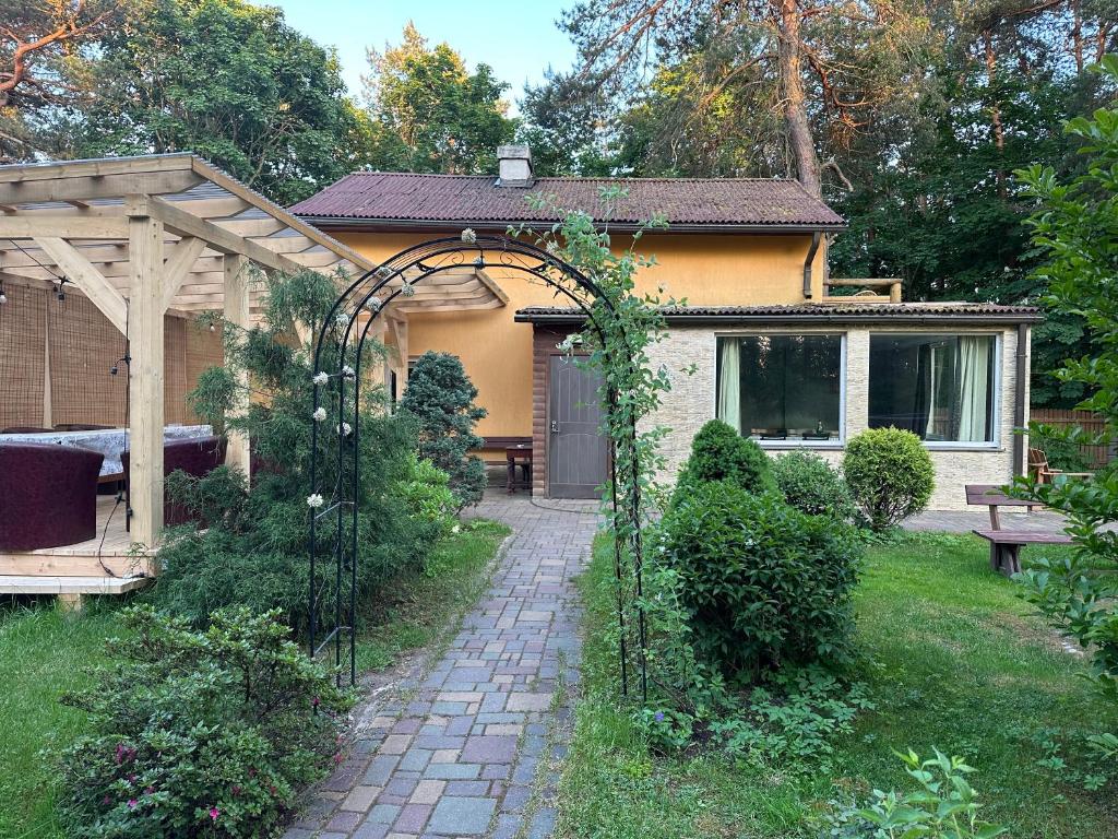 a garden with an archway in front of a house at House By The Sea With Hot Tub in Rīga
