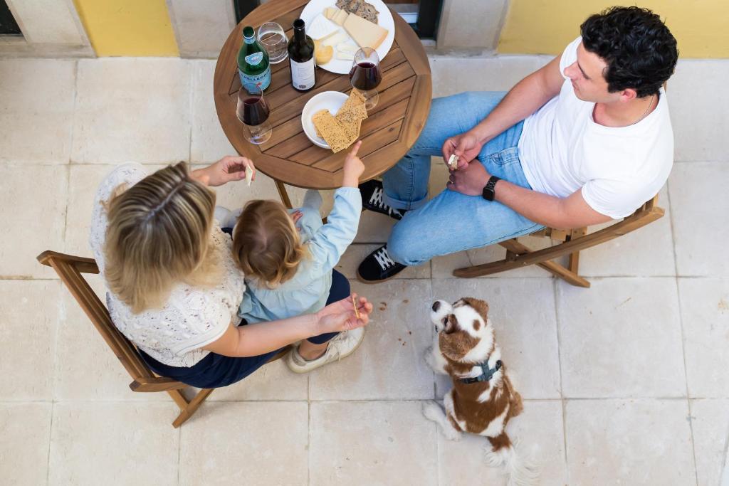 um grupo de pessoas sentadas à volta de uma mesa com um cão em The Haus - Alegria em Lisboa