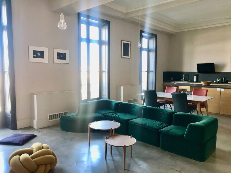 un salon avec un canapé vert et des tables dans l'établissement Elégant T2 climatisé sur canal, à Sète
