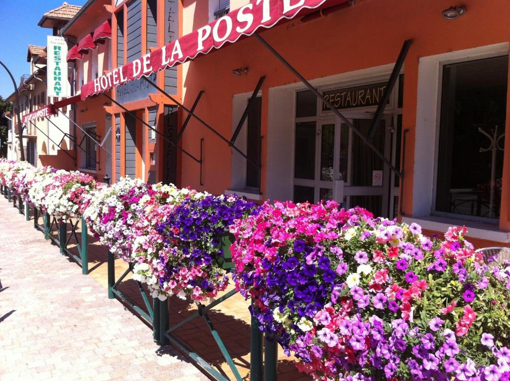 una fila de flores delante de un edificio en Hotel De La Poste, en Espinasses