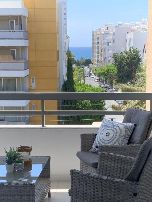 a balcony with two chairs and a glass coffee table at Shiny Blue Apartment in Limassol