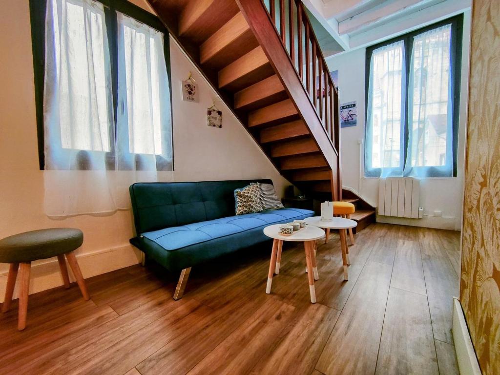 - un salon avec un canapé vert et un escalier dans l'établissement Rêves & Bois - Séjour à Auxerre, à Auxerre