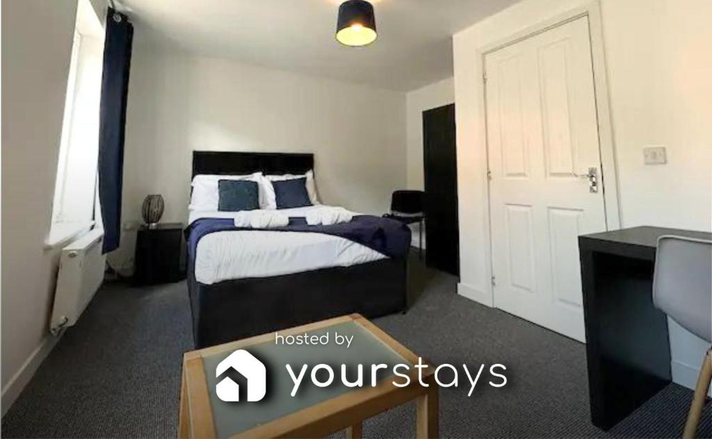 a bedroom with a bed and a desk and a tv at Chervil House by YourStays in Newcastle under Lyme