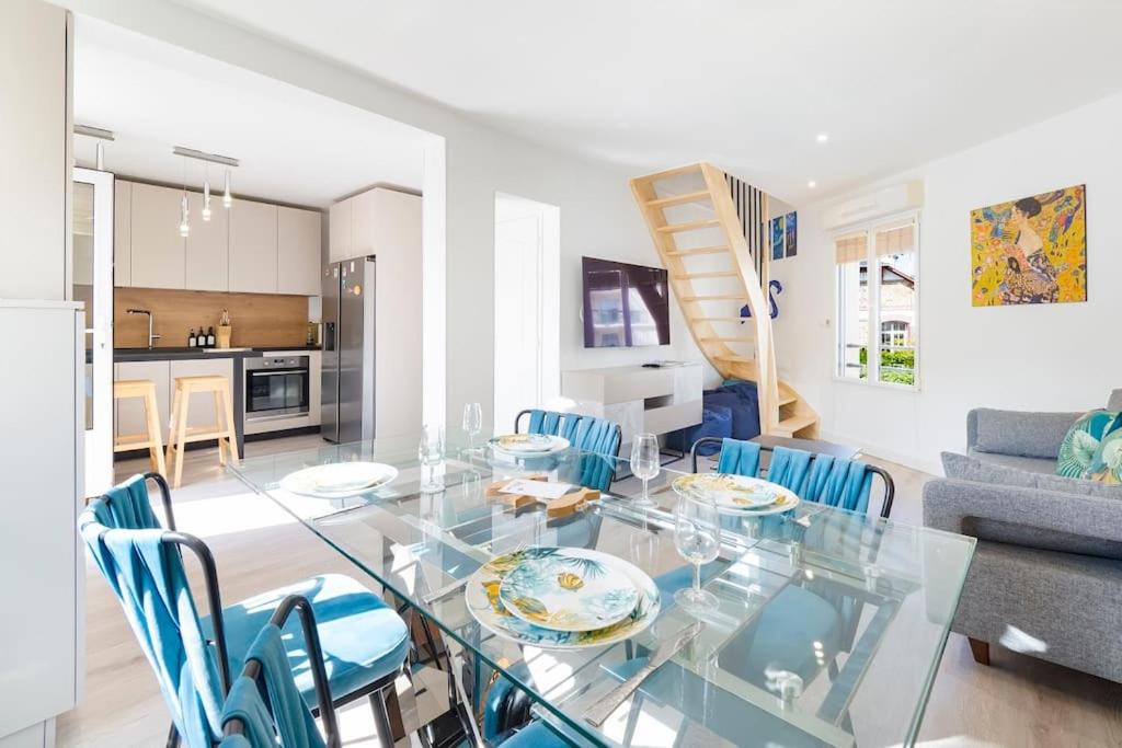 - une salle à manger et un salon avec une table et des chaises en verre dans l'établissement Duplex & jardin Marché La Baule, à La Baule