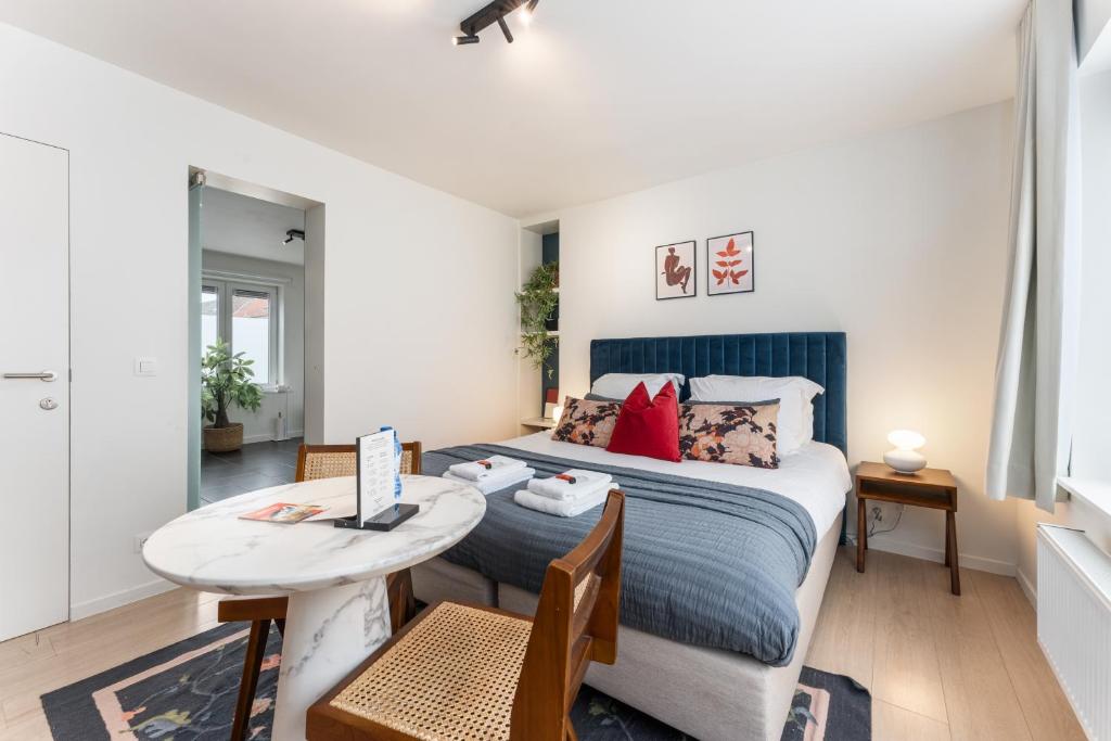 een slaapkamer met een bed en een kleine tafel bij Fall Eighteen by Romy&Travis in Brugge