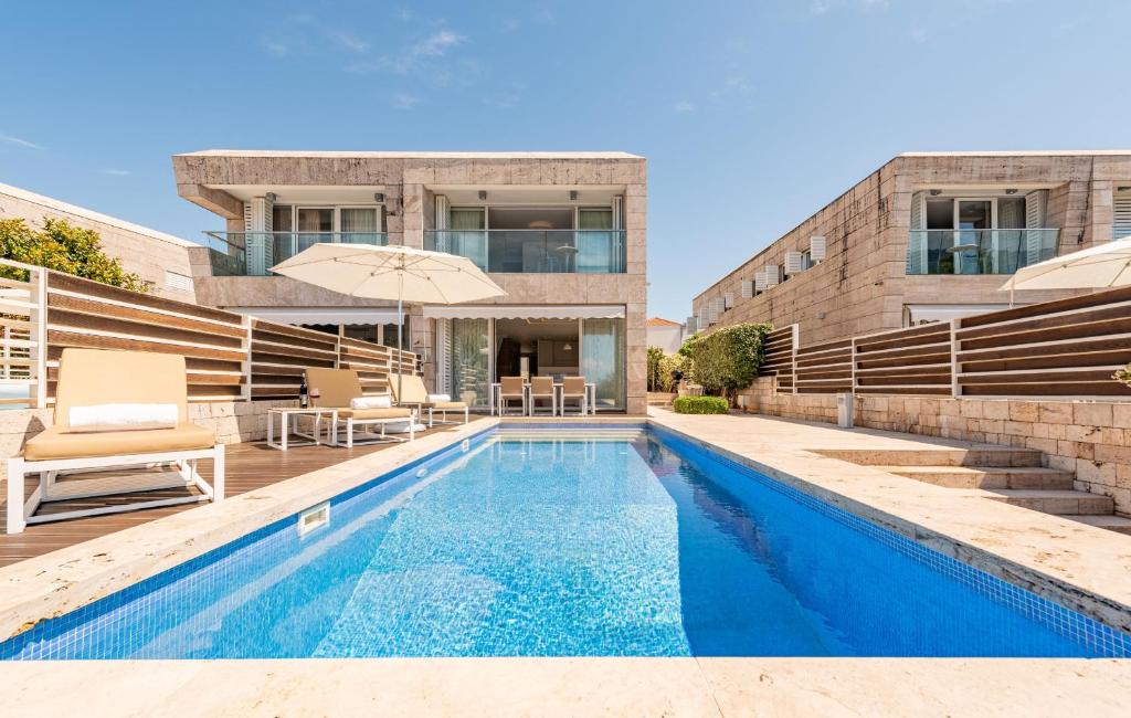 a swimming pool in front of a building at Villa Calla ZadarVillas in Petrcane