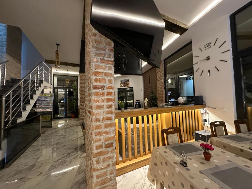 a restaurant with a table and a clock on the wall at Bosfor Hotel in Dobra Voda
