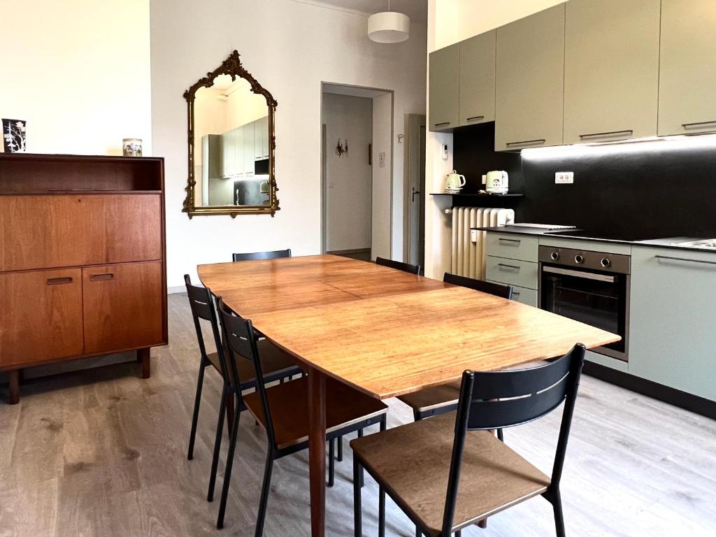 uma grande cozinha com uma mesa de madeira e cadeiras em ComeCasa near Piazza Vittorio 2 Bedrooms em Turim