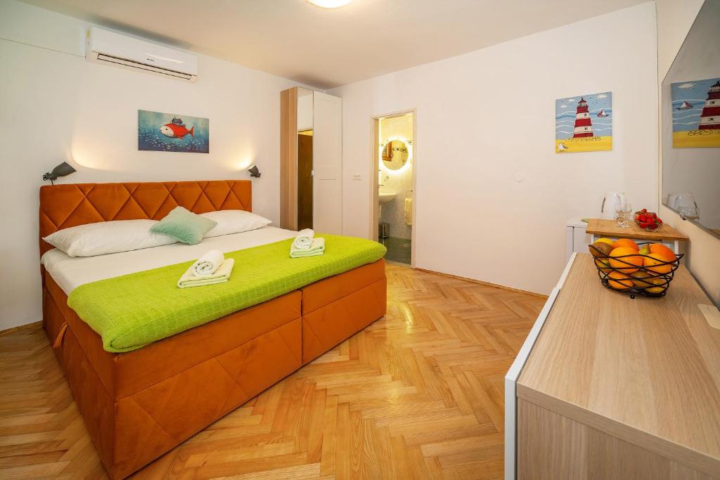 1 dormitorio con 1 cama grande con manta verde en Apartment & Double Room Stanka, en Baška