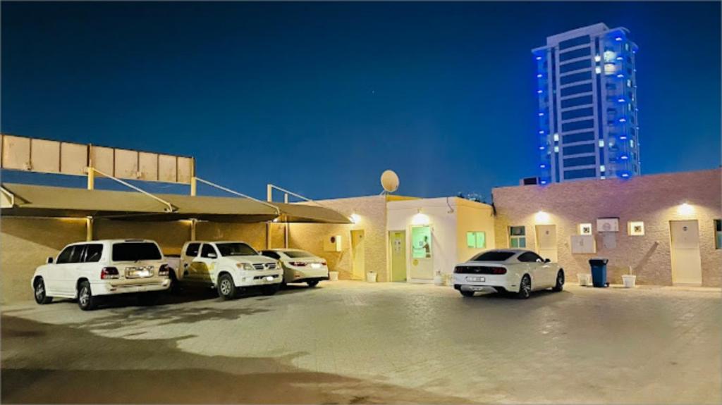 un parking avec des voitures garées devant un bâtiment dans l'établissement Lulu guest house, à Ras al Khaimah