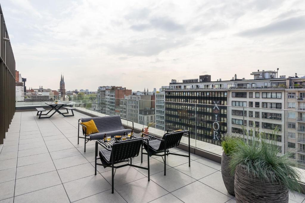 Un balcón con sillas y mesas en un edificio en YAYS Antwerp Opera by Numa, en Amberes
