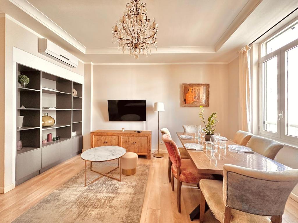 une salle à manger avec une table et un lustre dans l'établissement Le Zen-Appartement 3 Pièces Cannes Centre, à Cannes