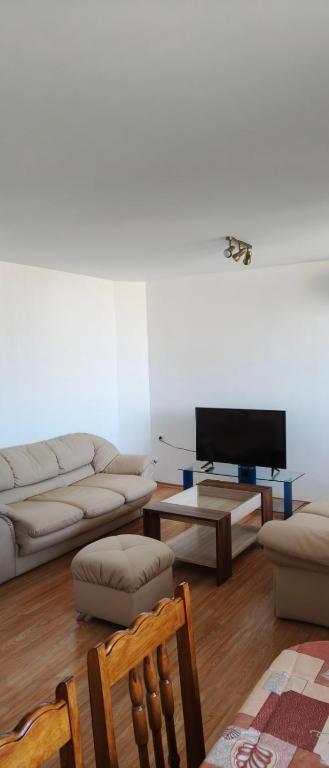a living room with a couch and a tv at апартамент CITY HOME 22 in Yambol
