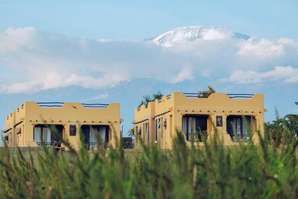 a yellow building with a mountain in the background at The Maridadi Hotel in Moshi