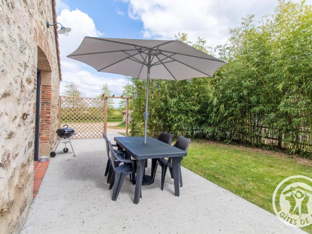 a black table with chairs and an umbrella at Gîte cosy entre Cholet et Puy du Fou, terrasse, accueil PMR, proche sites touristiques, parking inclus - FR-1-622-32 in Saint-Christophe-du-Bois