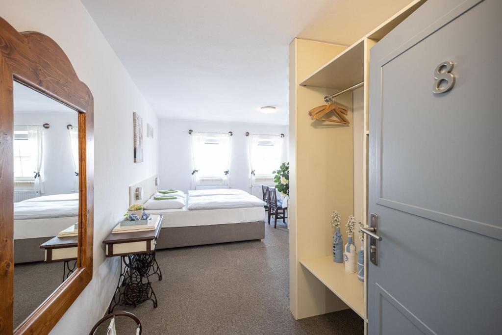 sypialnia z łóżkiem, biurkiem i drzwiami w obiekcie Hotel u Budvaru w Czeskich Budziejowicach
