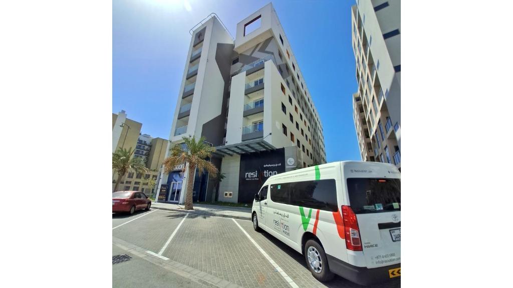 a white van parked in front of a building at Resivation Hotel in Dubai