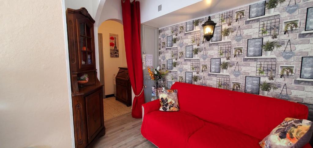 - un canapé rouge dans une pièce dotée d'un mur en briques dans l'établissement vadon geneletti, à Fréjus