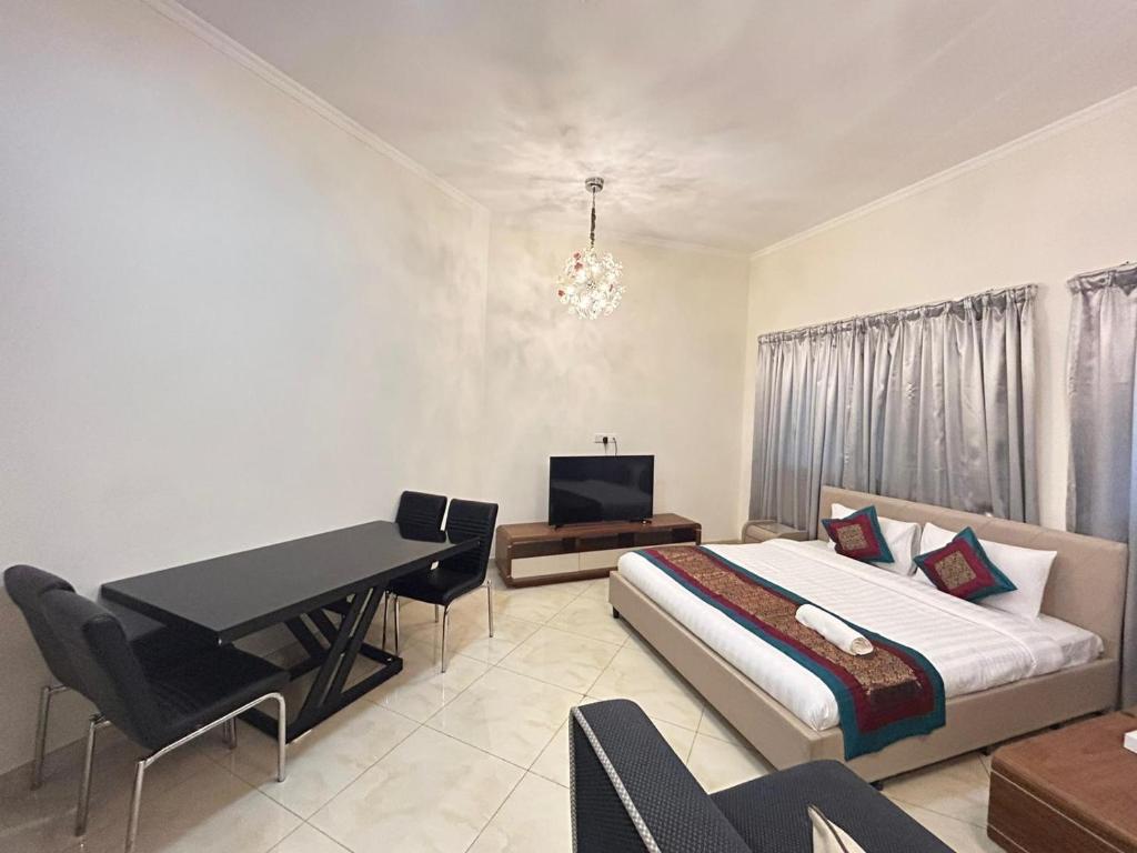 a bedroom with a bed and a desk and a table at Al Hayat Suites Apartment in Manama