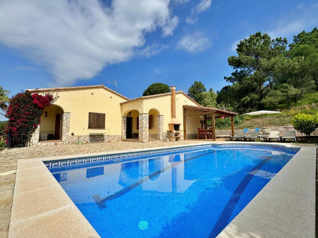 a large swimming pool in front of a house at Villa Puig Rosell in Calonge
