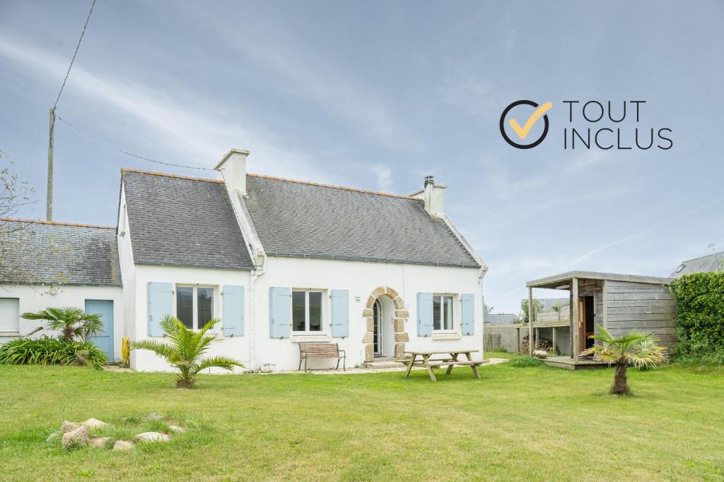 une maison blanche avec un banc dans une cour dans l'établissement TY GWENN - Jolie Maison avec sauna proche mer, à Ploudalmézeau