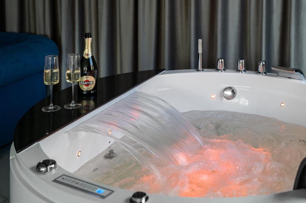 a bath tub with two champagne bottles and wine glasses at Mi Bella 1 in Gdynia