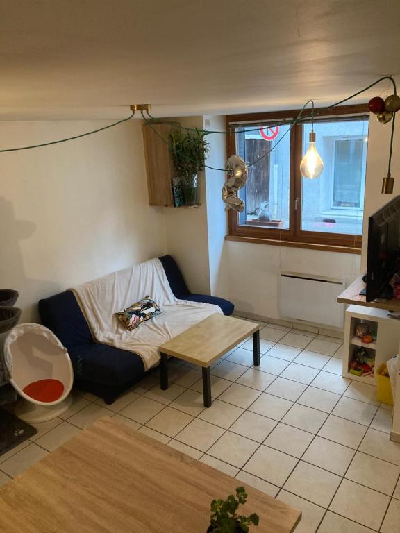 un salon avec un canapé et une table dans l'établissement Maison de ville idéalement située, au Bourg-dʼOisans