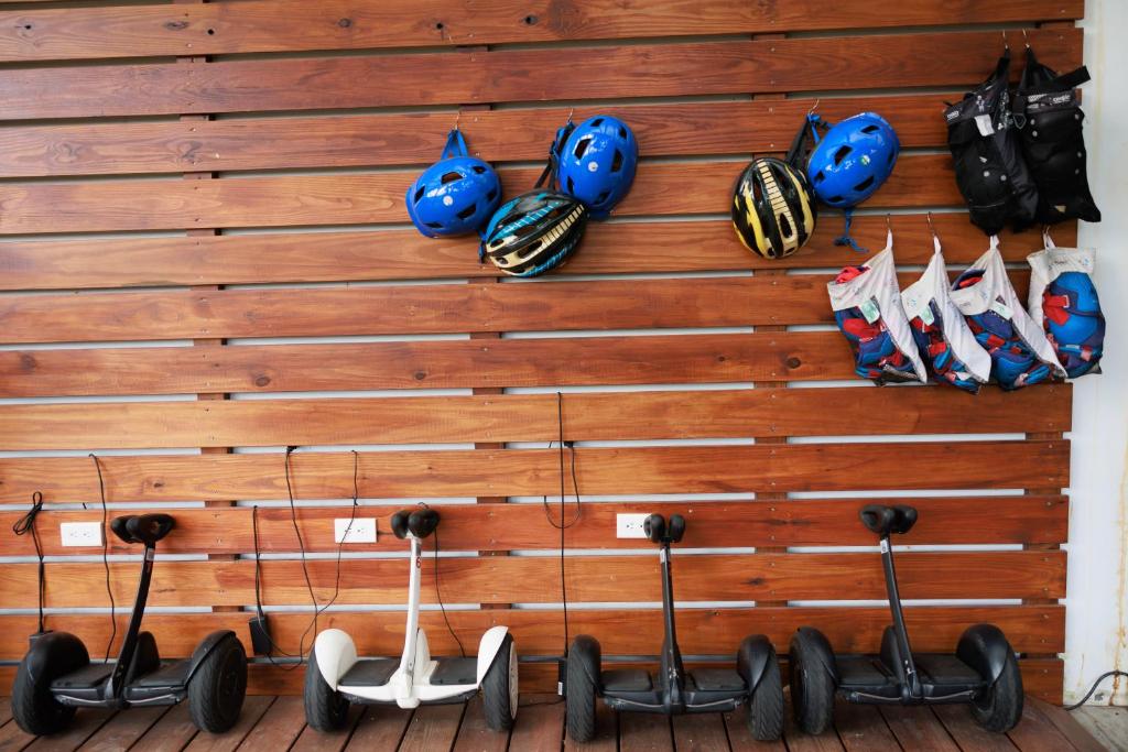 a wall with helmets and scooters on it at Volando Kenting in Hengchun