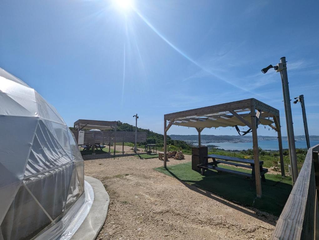 ein Auto, das neben einer Bank parkt, mit dem Ozean im Hintergrund in der Unterkunft 8POINT RESORT Okinawa in Nanjō