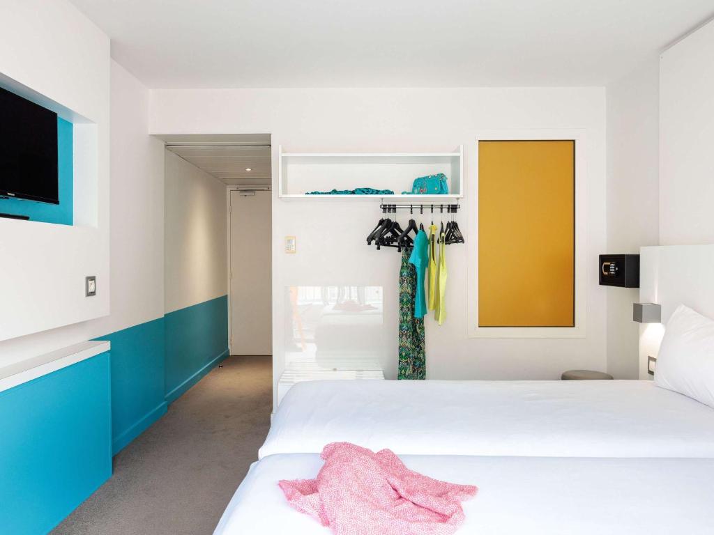 a bedroom with two beds and a tv at Ibis Styles Menton Centre in Menton