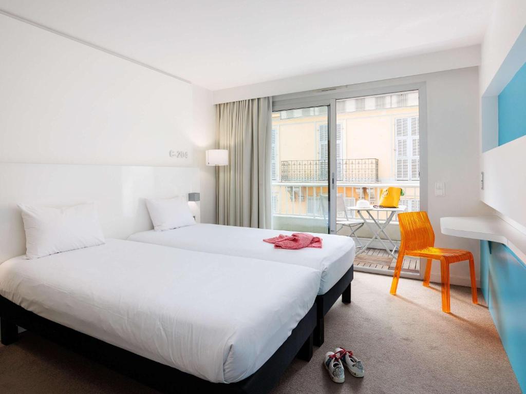 a hotel room with a large bed and a window at Ibis Styles Menton Centre in Menton