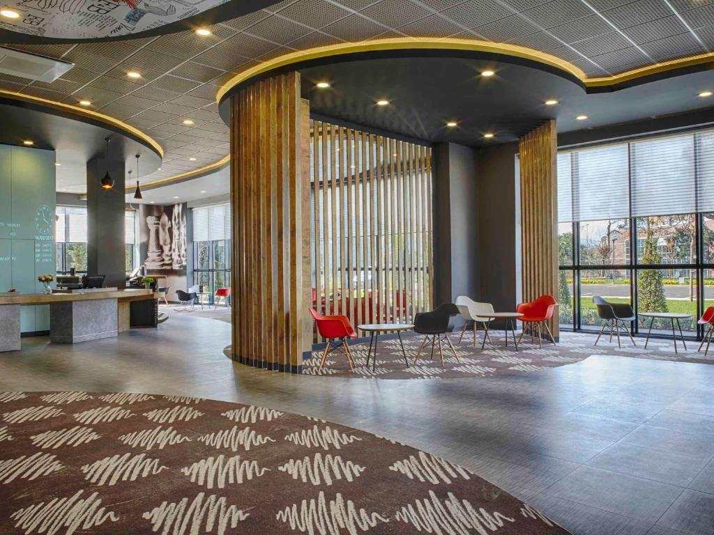 a lobby with chairs and tables in a building at Ibis Istanbul Tuzla Hotel in Tuzla