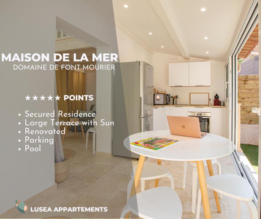 - une cuisine avec une table blanche et un ordinateur portable dans l'établissement La Maison de la mer, Golfe de saint-tropez, à Gassin