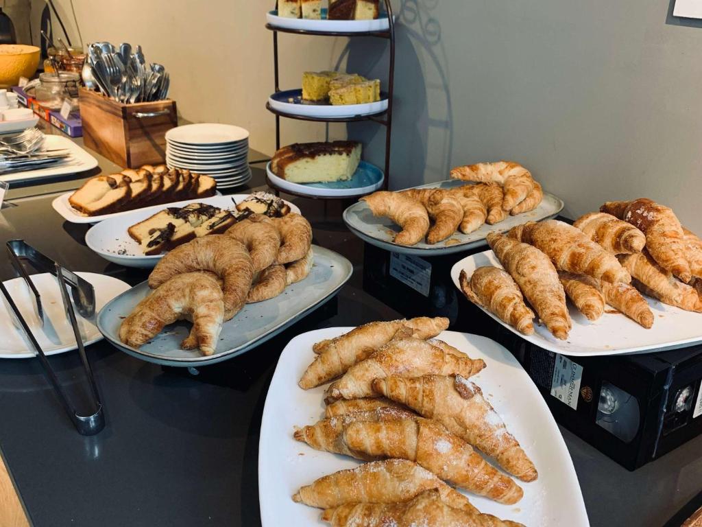 a table topped with plates of pastries and desserts at ibis Styles Montevideo Biarritz in Montevideo