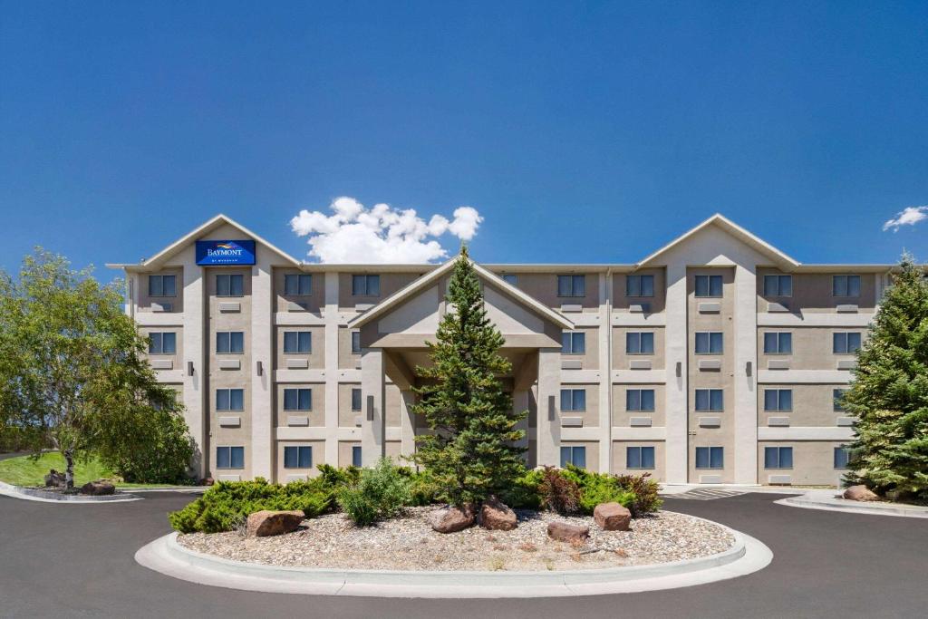 a large building with a tree in front of it at Baymont by Wyndham Elko in Elko