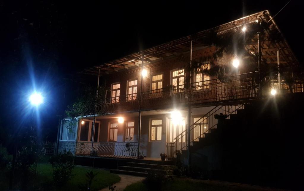 une maison avec des lumières sur son côté la nuit dans l'établissement Tkhibuli geust house, à Tqibuli