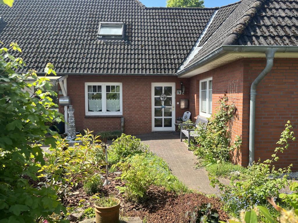 a red brick house with a pathway leading to the front door at Nord-Ostsee-Nest in Tarp