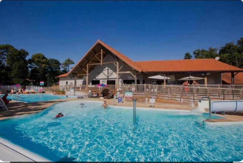 une grande piscine devant un immeuble dans l'établissement Mobil home dans camping le domaine de soulac siblu, à Soulac-sur-Mer