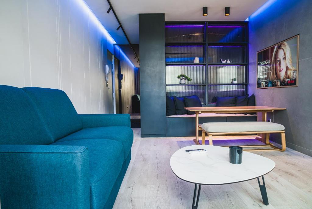 un salon avec un canapé bleu et une table dans l'établissement Blue King Suite - Triangle d'Or, à Villeurbanne