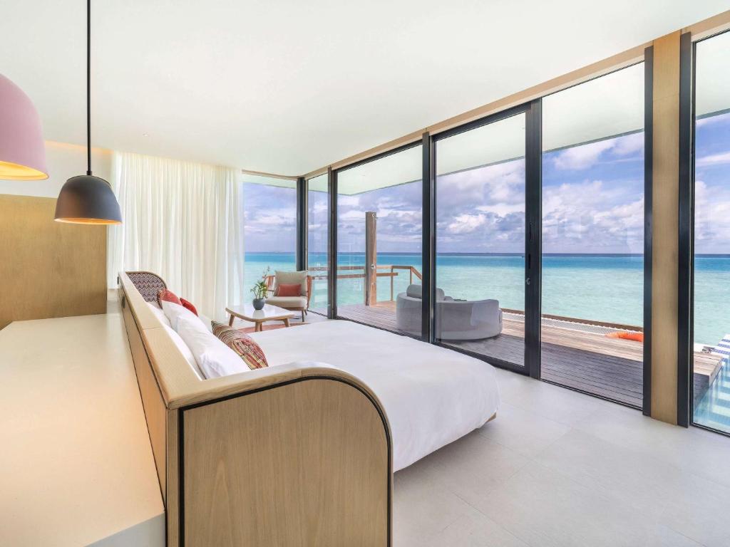 a bedroom with a bed and a view of the ocean at SO/ Maldives in South Male Atoll