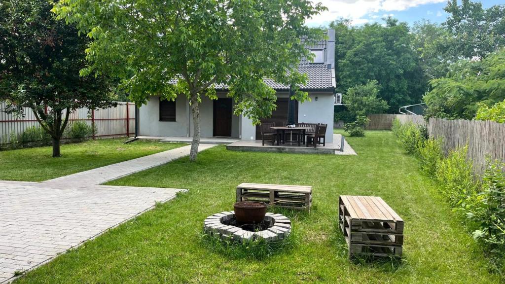 a yard with a picnic table and a bench and a house at Habitat of Dreams in Makó