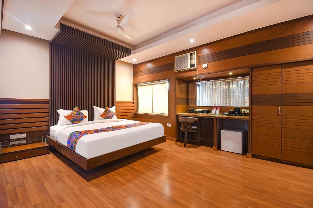 a bedroom with a large bed and a kitchen at FabHotel Shivani International in Rānchī
