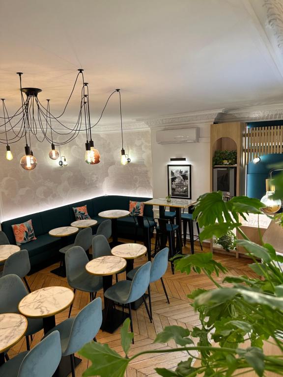 ein Restaurant mit Tischen und Stühlen und einer Couch in der Unterkunft Hôtel Océanic - Grands Magasins in Paris