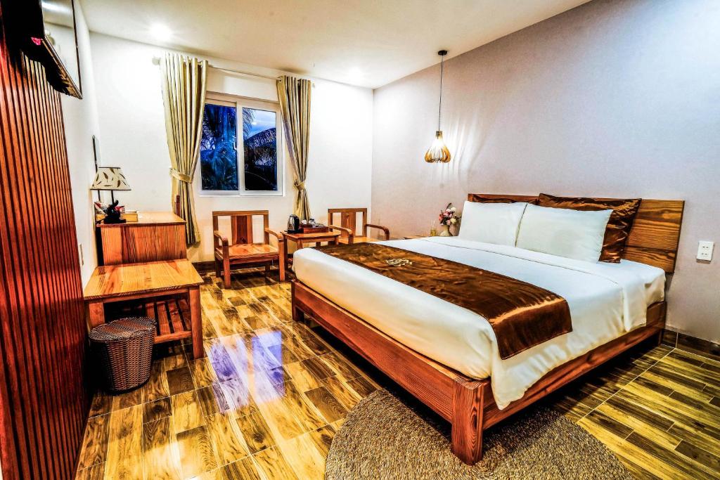 BB Hotel&Resort في فو كووك: غرفة نوم بسرير كبير ومكتب وكرسي