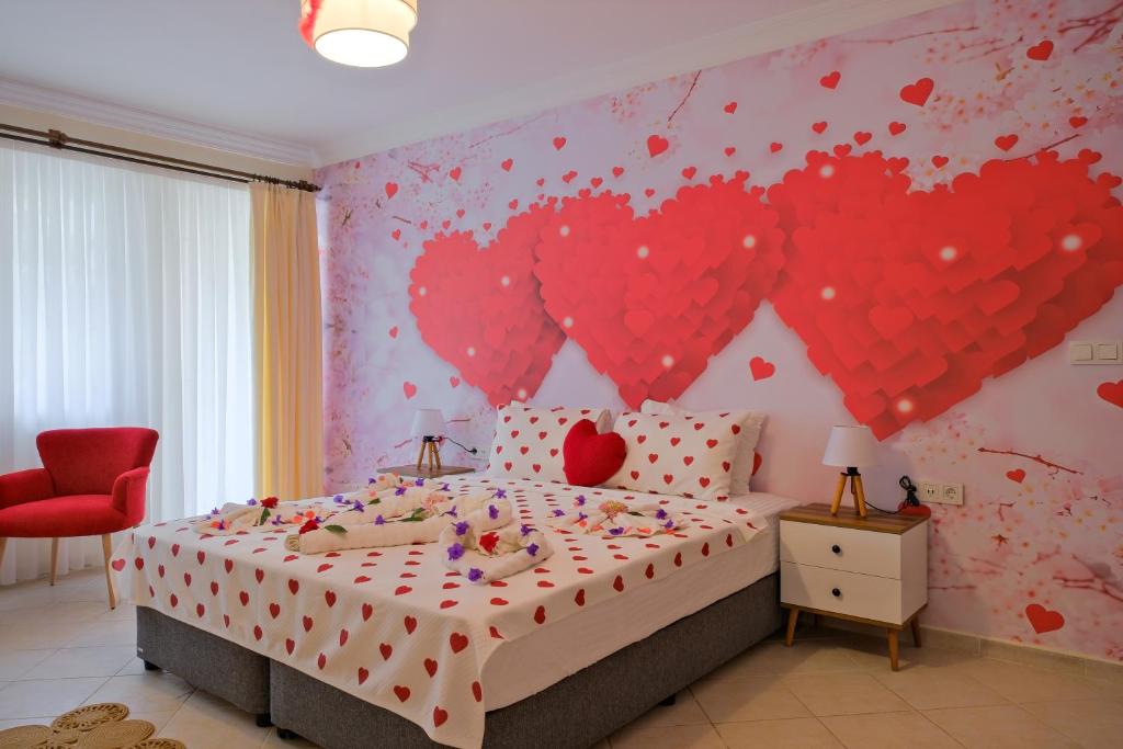 a bedroom with a bed with hearts on the wall at Larimar Suite Hotel in Oludeniz